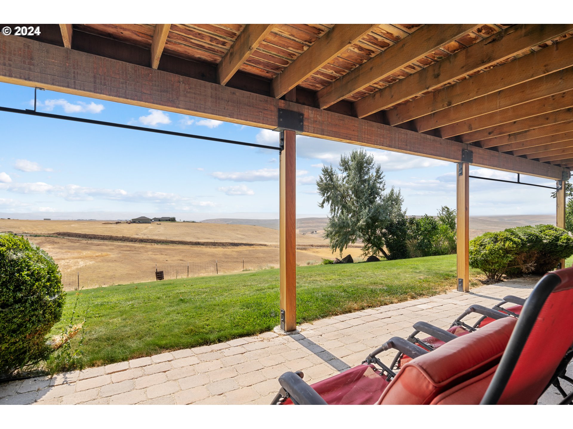 72217 Quill Point Pendleton, OR 97801 - Photo 47 of 48 a view of a patio with lawn chairs floor to ceiling window and wooden floor