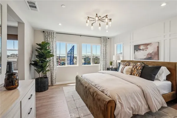 a spacious bedroom with a large bed and a wooden floor