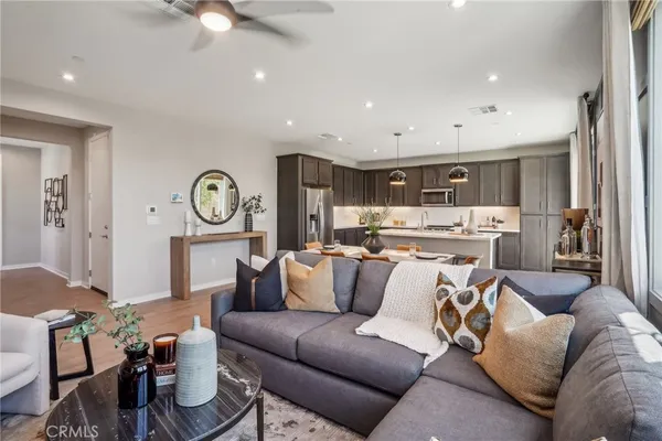 a living room with furniture and a view of kitchen