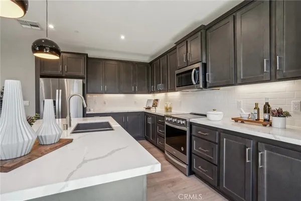 a kitchen with stainless steel appliances granite countertop a sink stove and cabinets