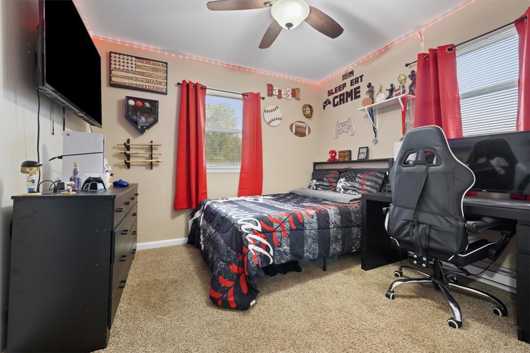 1482 Lee Road Troy, OH 45373 - Photo 13 of 30 This cozy bedroom features a ceiling fan, a window with blinds, and soft carpet flooring.