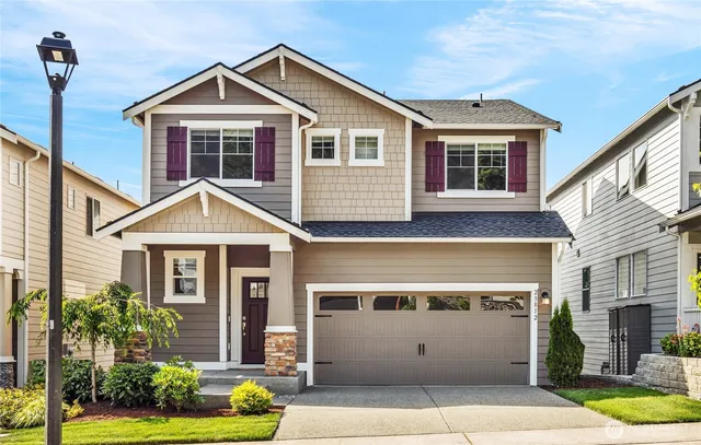 a front view of a house with a yard and potted plants