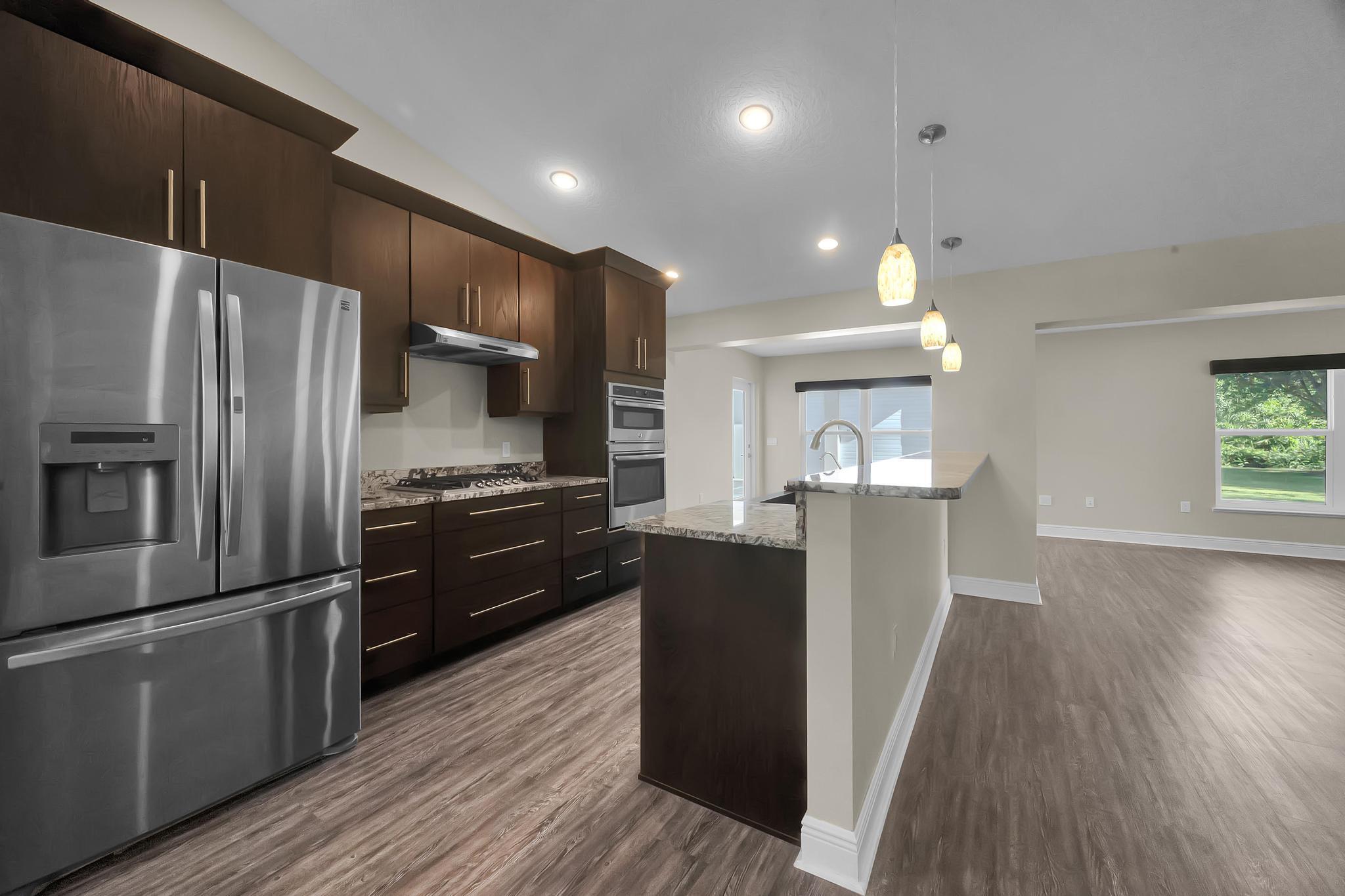 8330 Hidden Pines Road Fort Pierce, FL 34945 - Photo 13 of 34 a kitchen with kitchen island wooden floors appliances and cabinets