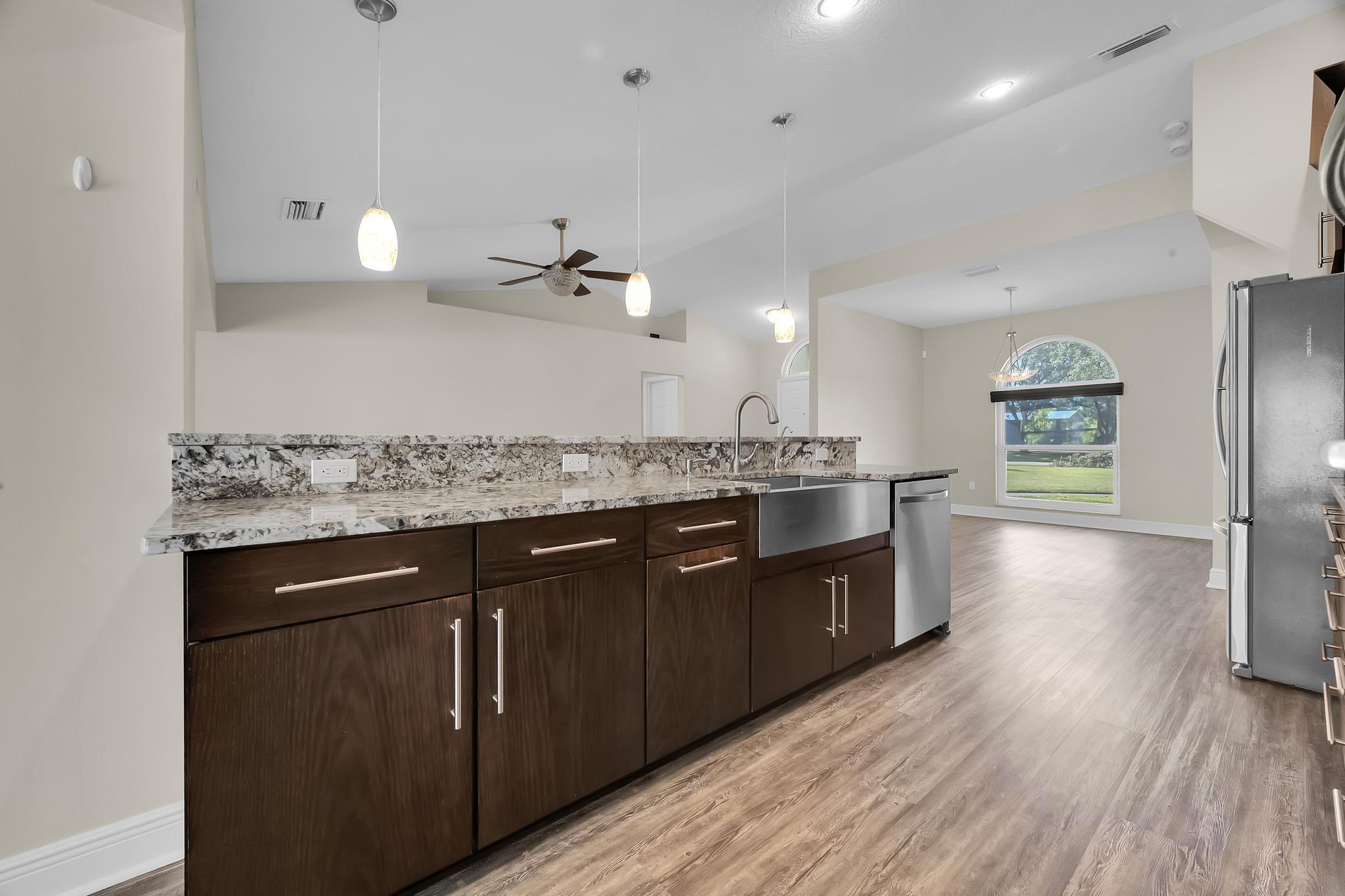 8330 Hidden Pines Road Fort Pierce, FL 34945 - Photo 14 of 34 a large kitchen with a center island wooden floor and stainless steel appliances