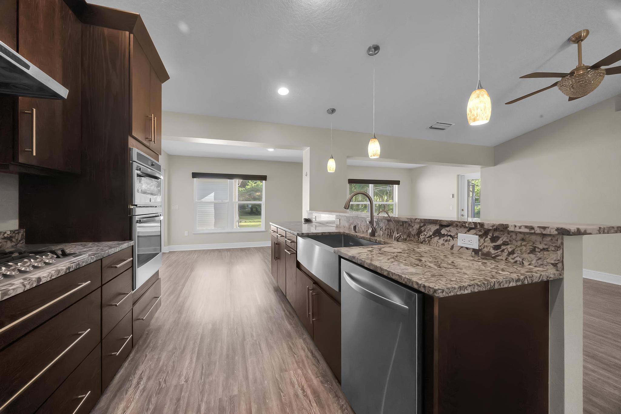 8330 Hidden Pines Road Fort Pierce, FL 34945 - Photo 15 of 34 a kitchen with a counter space a sink stainless steel appliances and cabinets