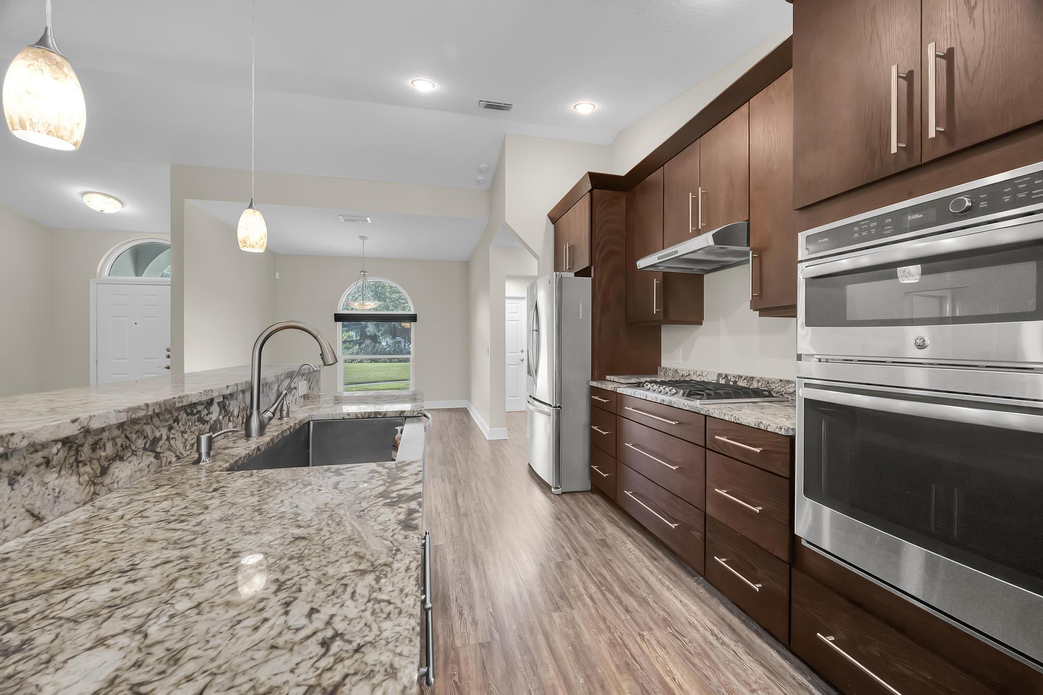 8330 Hidden Pines Road Fort Pierce, FL 34945 - Photo 16 of 34 a large kitchen with granite countertop a stove top oven and sink