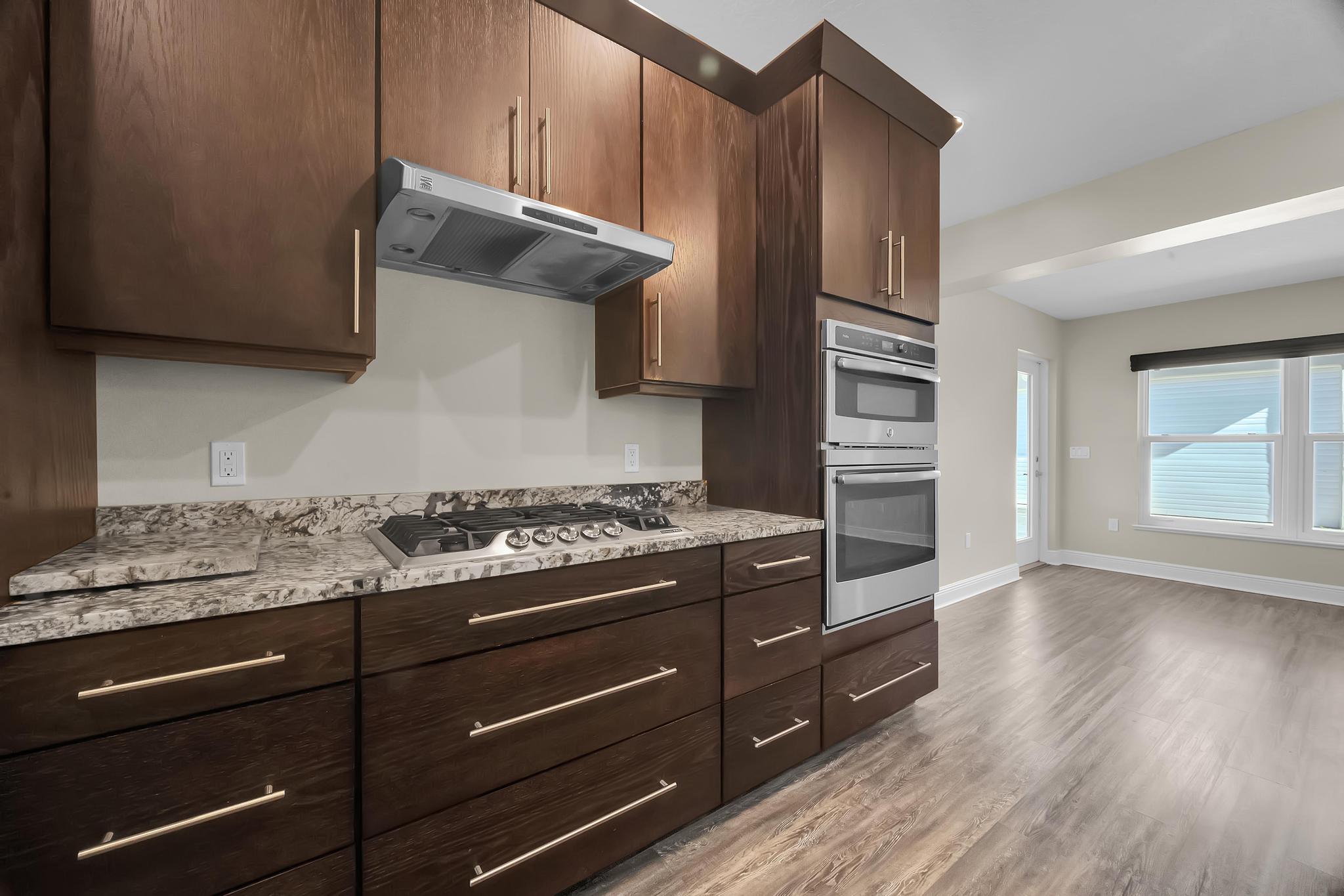 8330 Hidden Pines Road Fort Pierce, FL 34945 - Photo 17 of 34 a kitchen with granite countertop wooden cabinets and stainless steel appliances