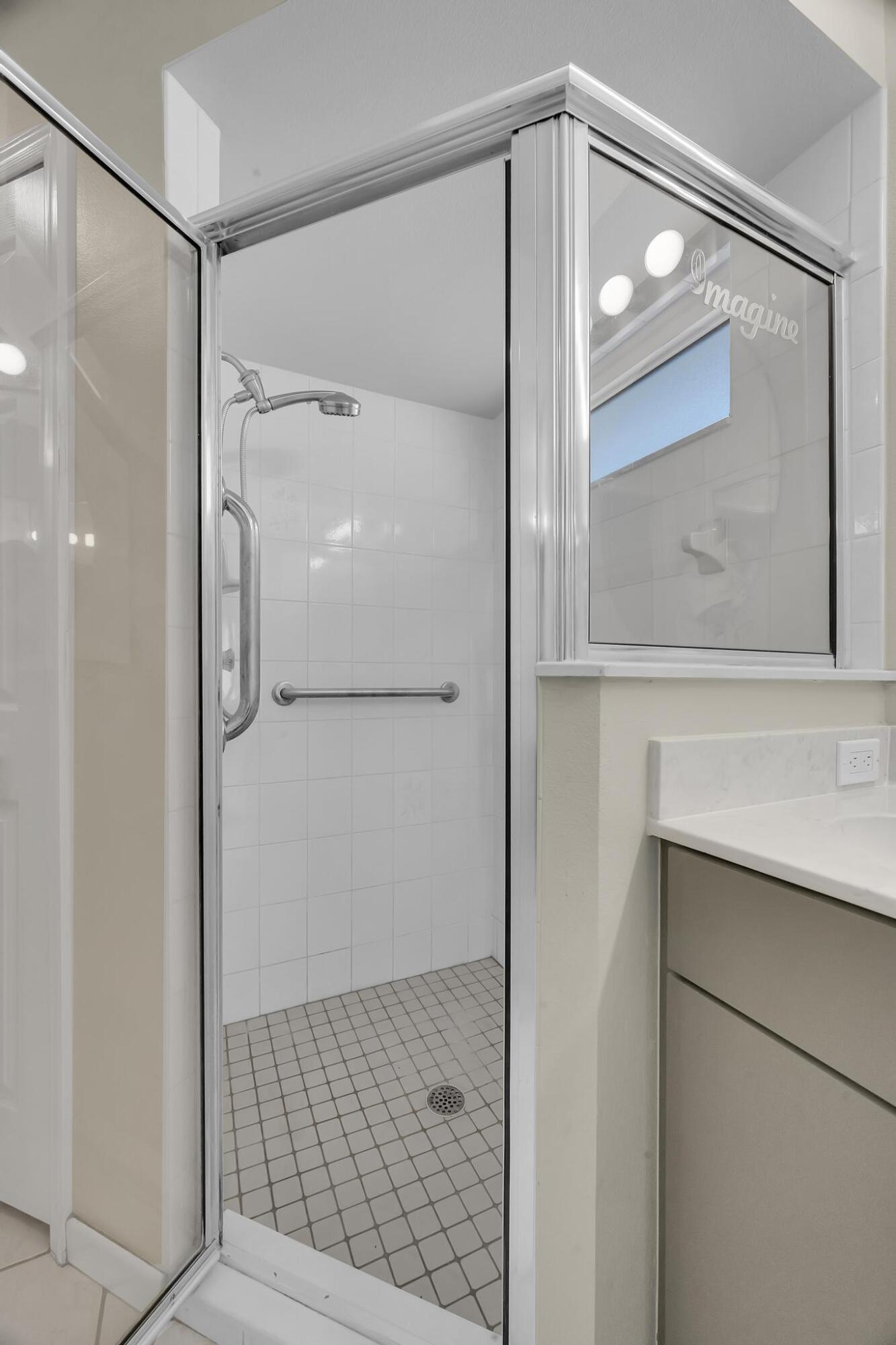 8330 Hidden Pines Road Fort Pierce, FL 34945 - Photo 26 of 34 a bathroom with a glass shower door and a mirror