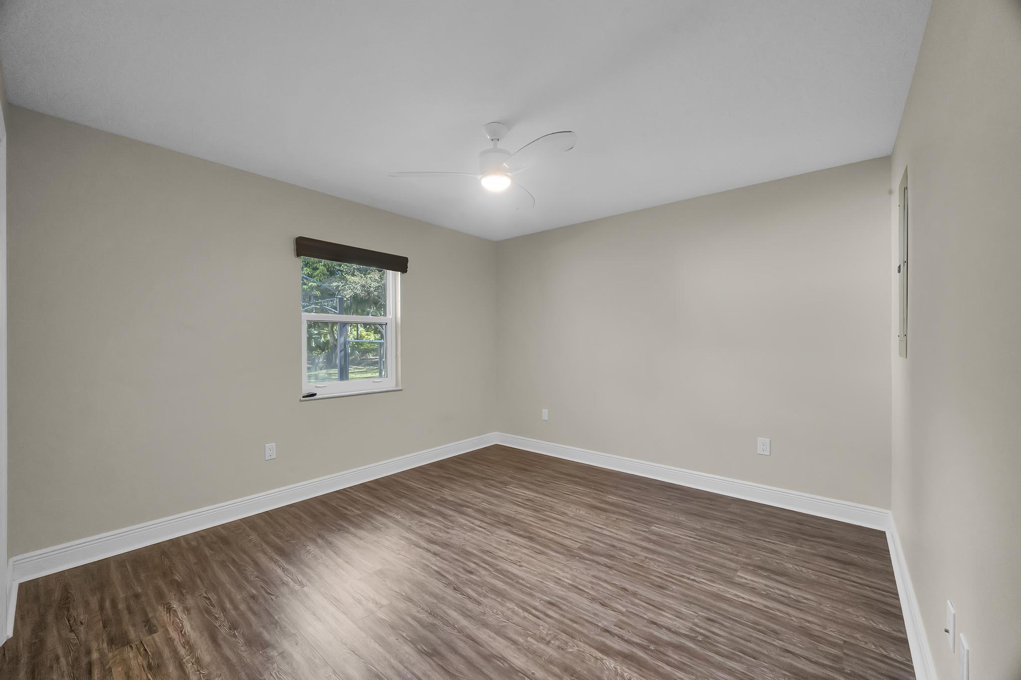 8330 Hidden Pines Road Fort Pierce, FL 34945 - Photo 29 of 34 an empty room with wooden floor and windows