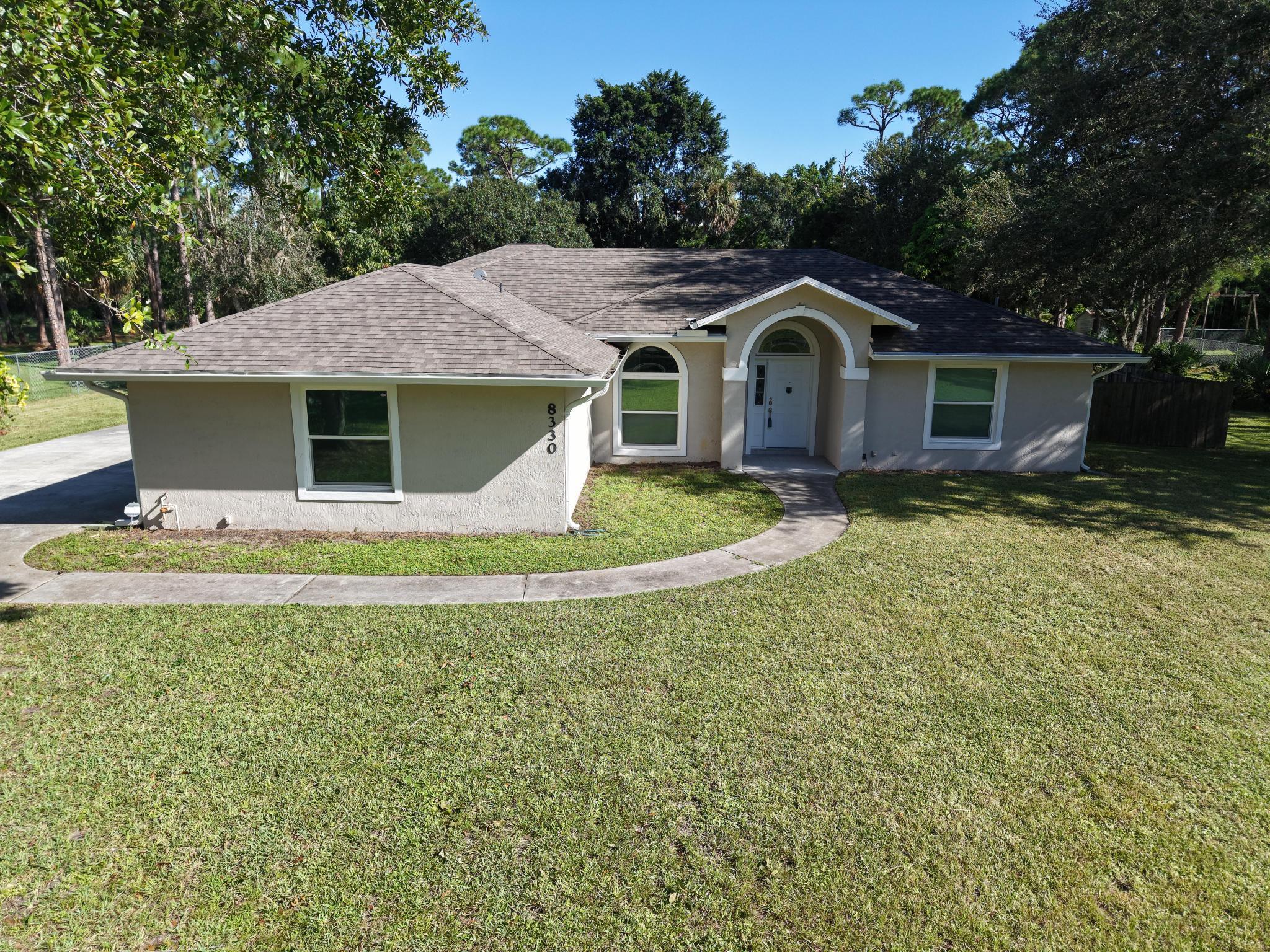 8330 Hidden Pines Road Fort Pierce, FL 34945 - Photo 3 of 34 a front view of a house with garden