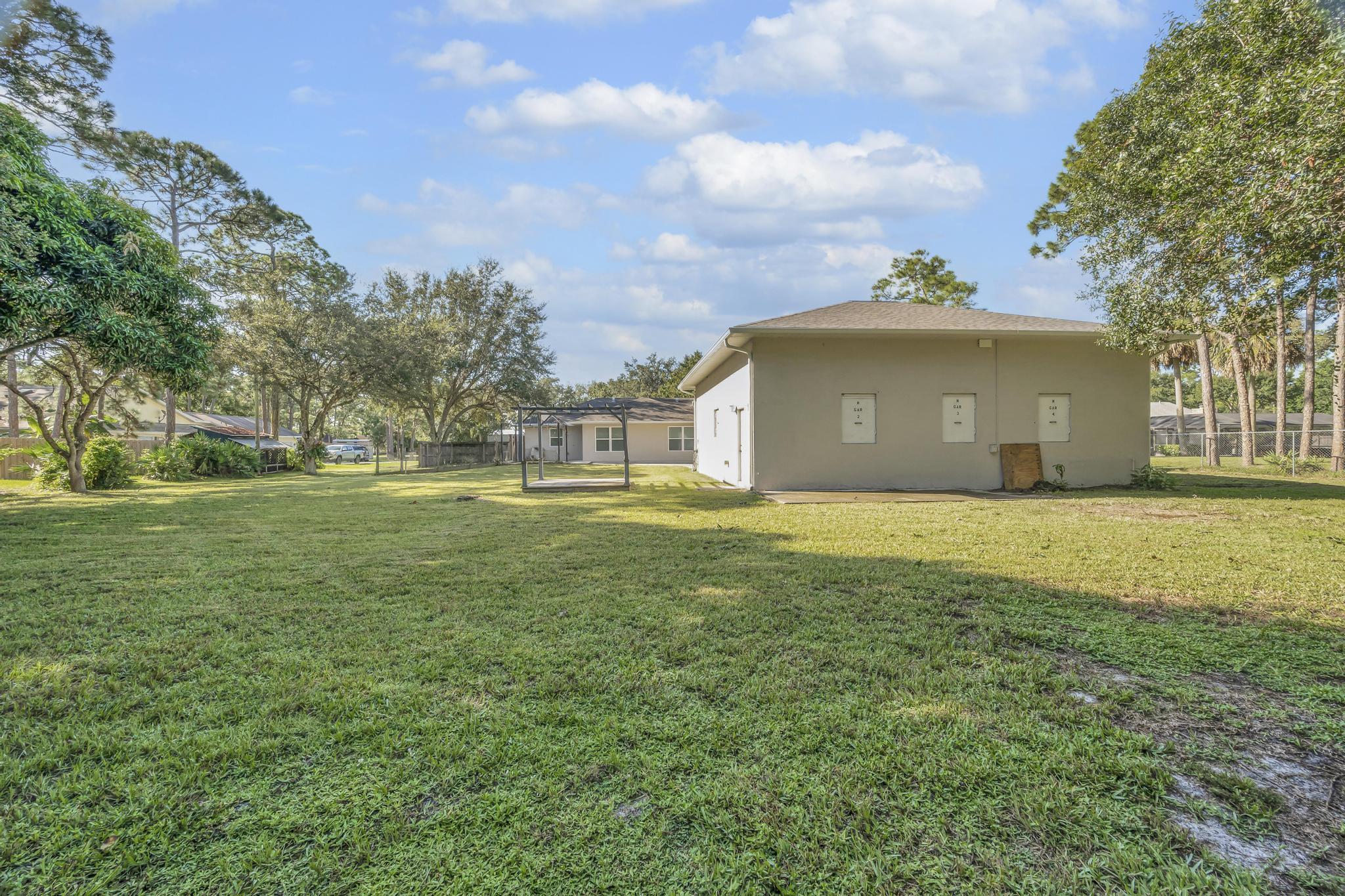8330 Hidden Pines Road Fort Pierce, FL 34945 - Photo 32 of 34 a front view of a house with a garden