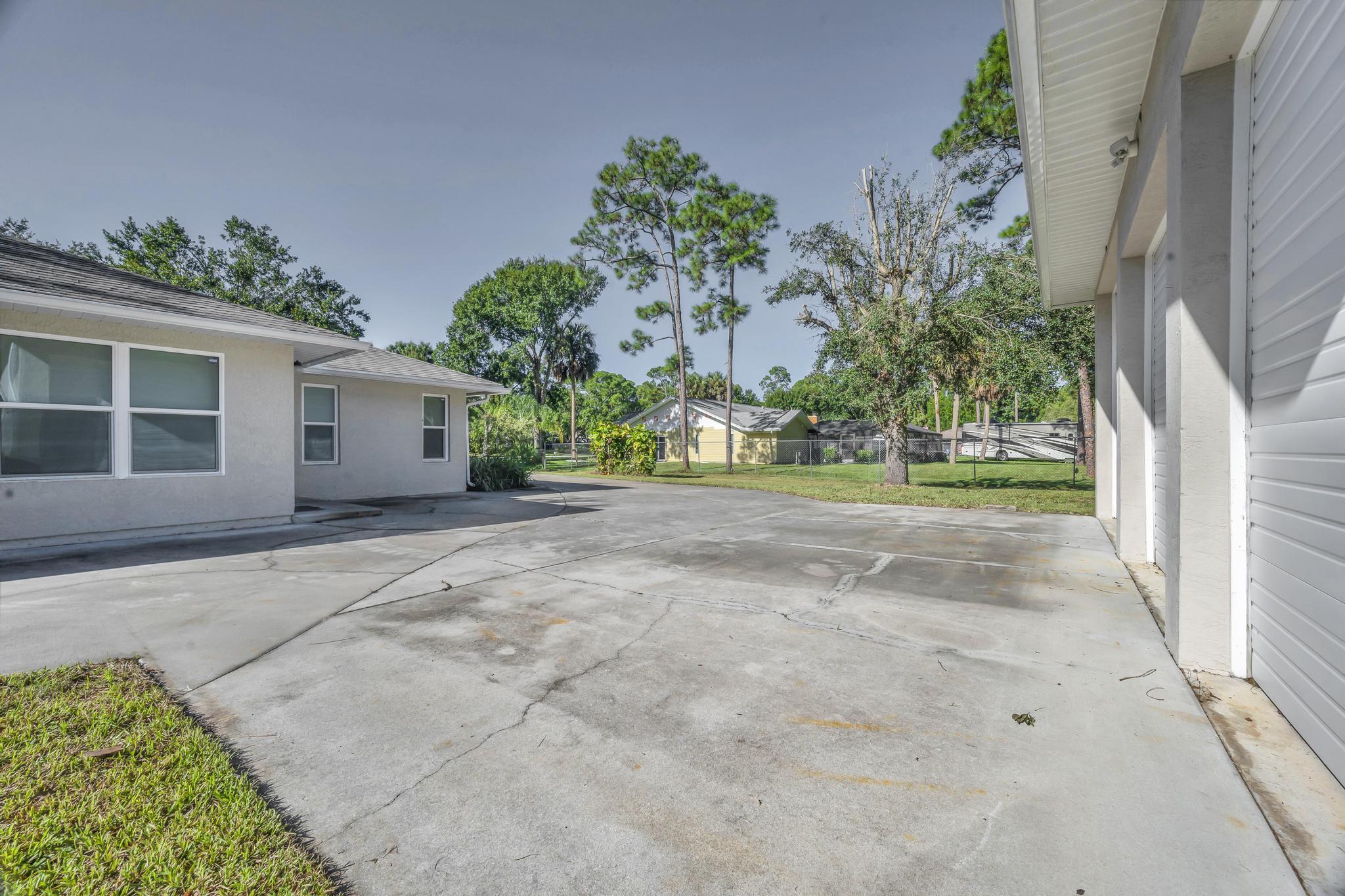 8330 Hidden Pines Road Fort Pierce, FL 34945 - Photo 34 of 34 a view of a house with a yard and potted plants