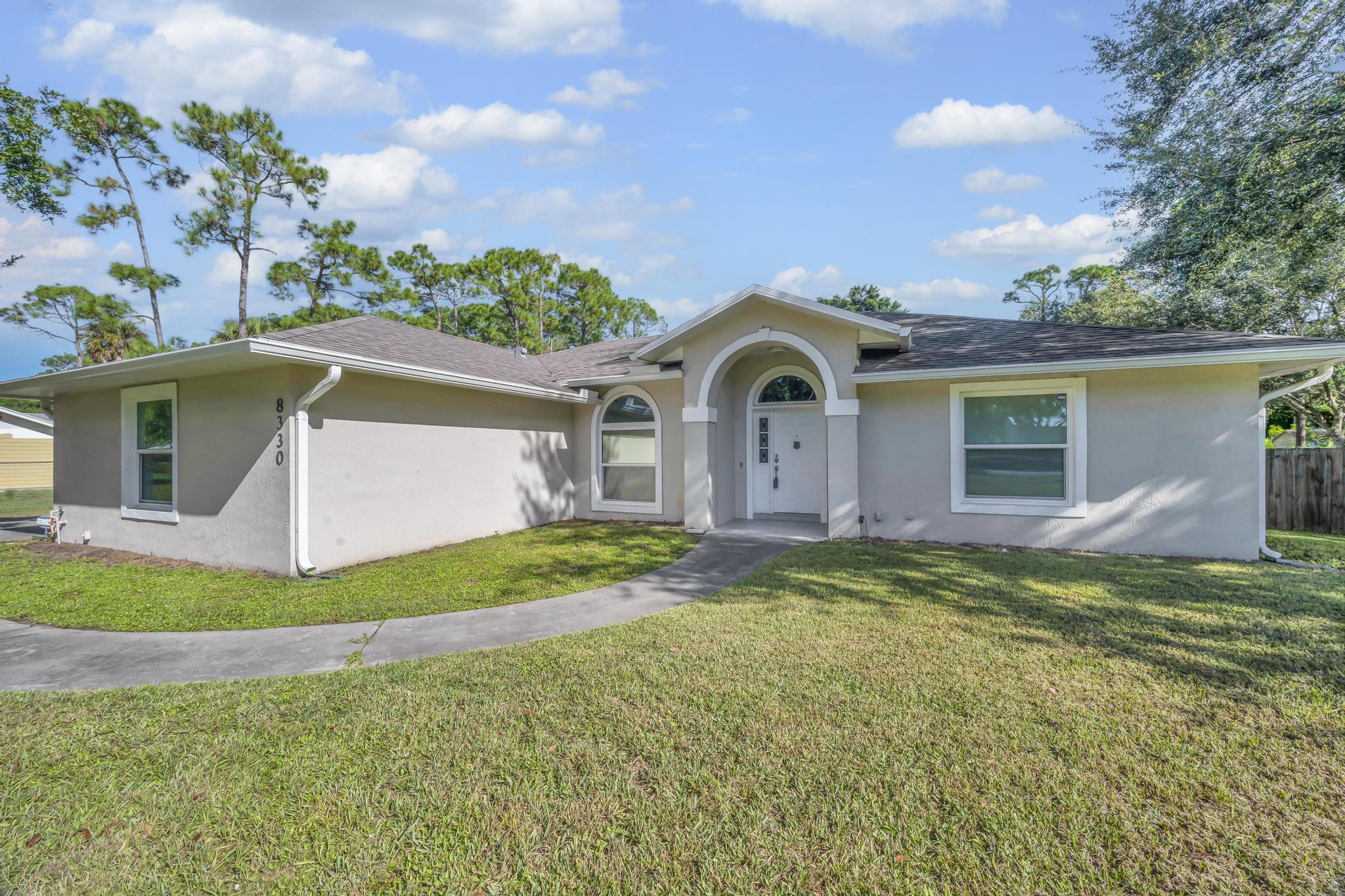 8330 Hidden Pines Road Fort Pierce, FL 34945 - Photo 5 of 34 a front view of a house with a yard and garage
