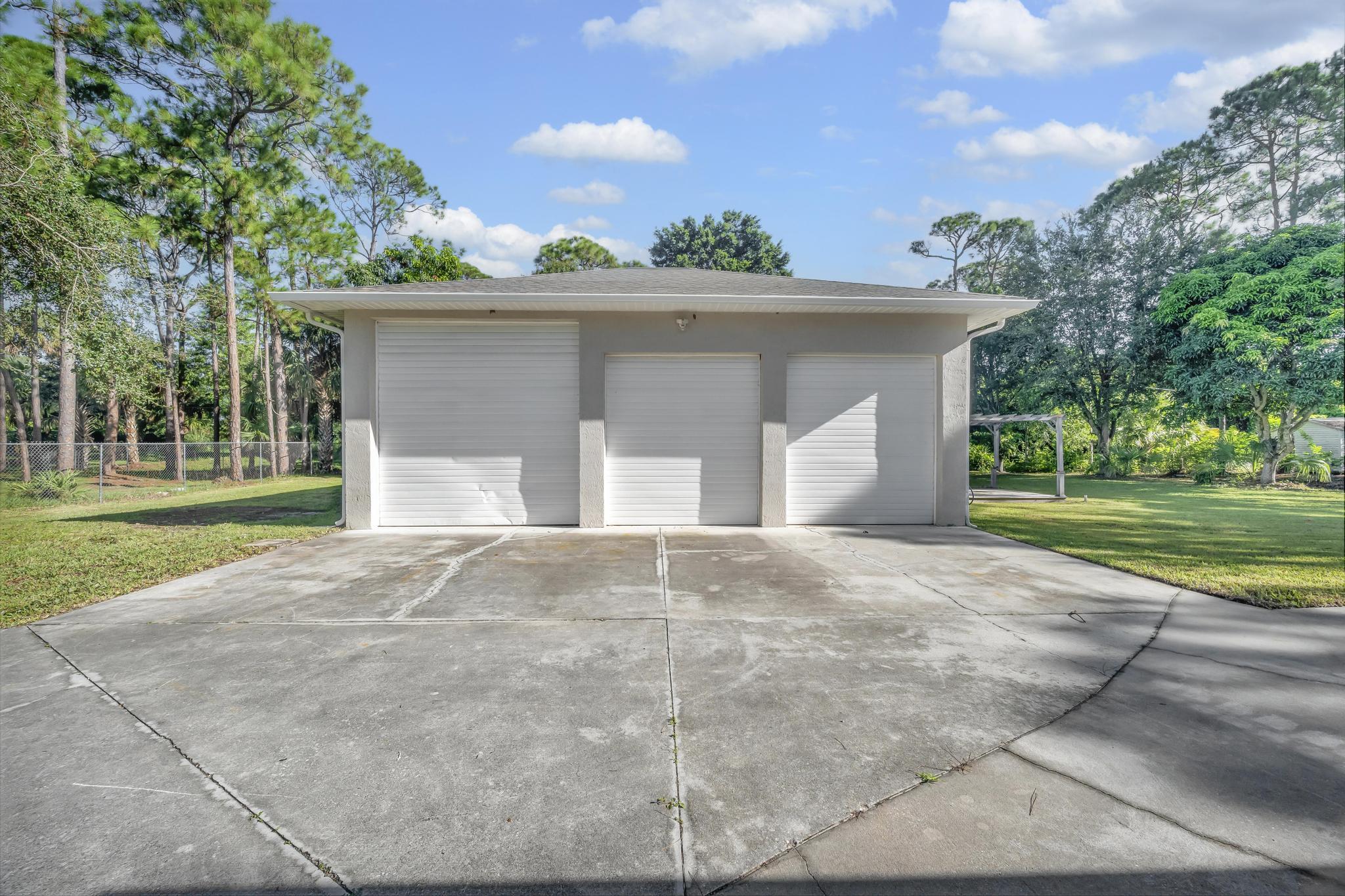 8330 Hidden Pines Road Fort Pierce, FL 34945 - Photo 6 of 34 a view of a house with a yard and garage