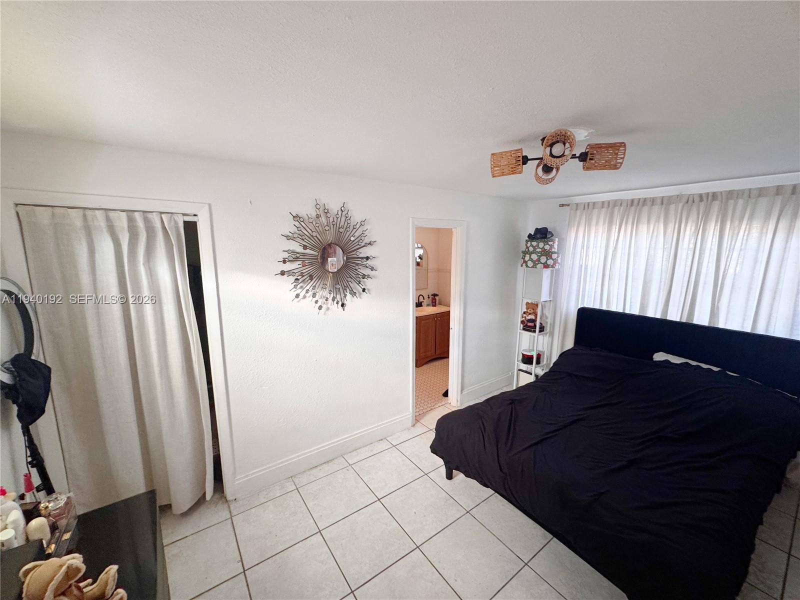 195 Northwest 135th Street Miami, FL 33168 - Photo 2 of 7 a bedroom with a bed and a mirror
