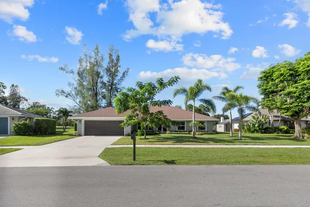a front view of a house with a yard and trees