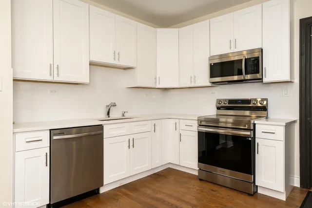 a kitchen with stainless steel appliances granite countertop a stove and a microwave