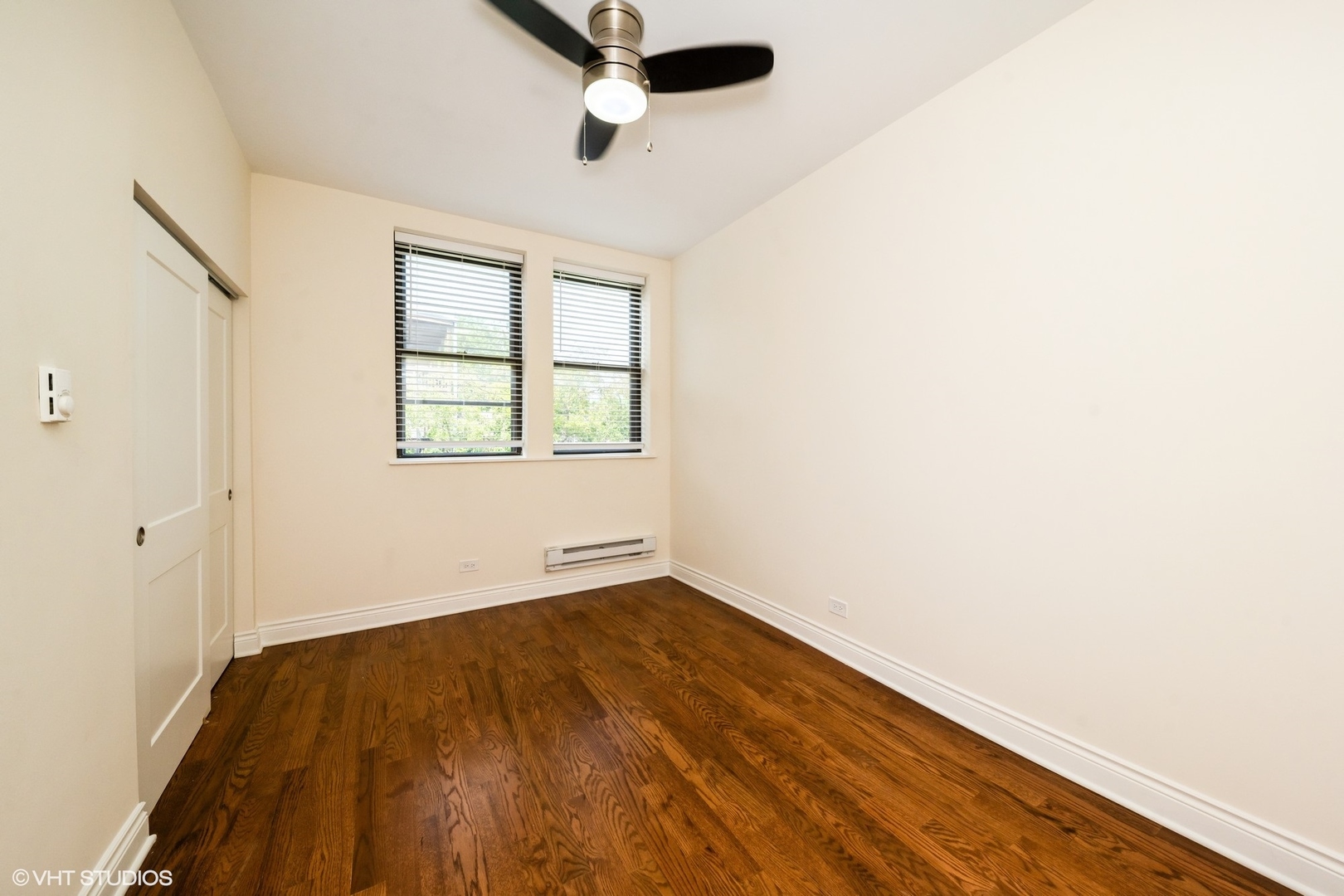 1006 East 54th Street, Unit J2 Chicago, IL 60615 - Photo 10 of 15 an empty room with wooden floor and windows