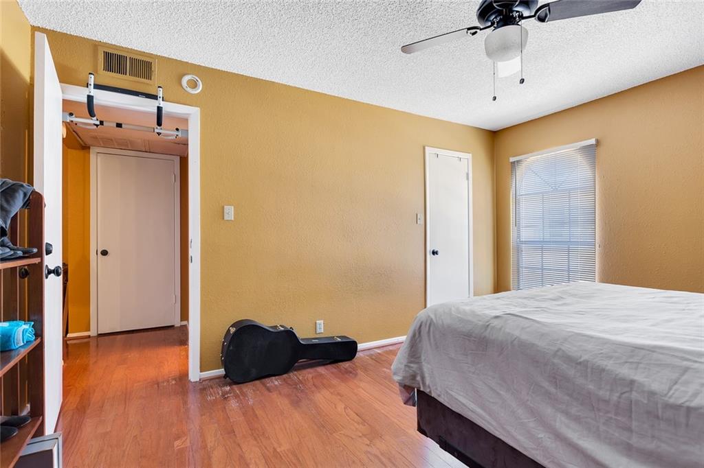 910 Duncan Lane, Unit 35 Austin, TX 78705 - Photo 12 of 20 Hardwood floors and a window with blinds provide a comfortable and private retreat.