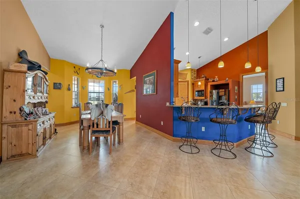 a kitchen with stainless steel appliances granite countertop a dining table chairs and granite counter tops
