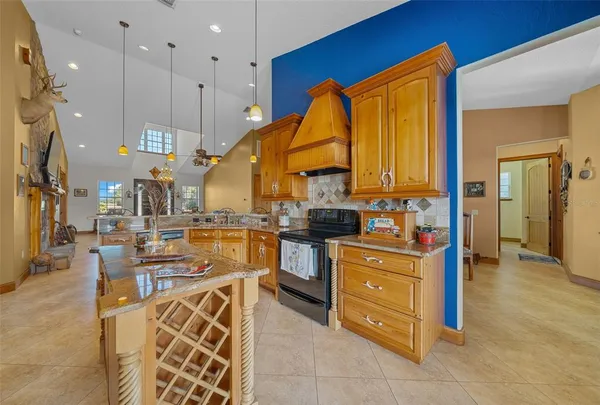 a view of a kitchen with kitchen island granite countertop wooden cabinets and stainless steel appliances