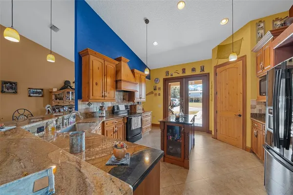 a kitchen with stainless steel appliances granite countertop a sink a stove and a refrigerator