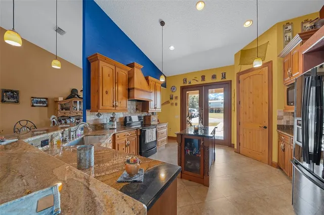 a kitchen with stainless steel appliances granite countertop a sink a stove and a refrigerator