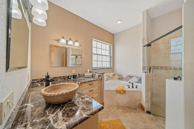 a spacious bathroom with a granite countertop tub sink and mirror