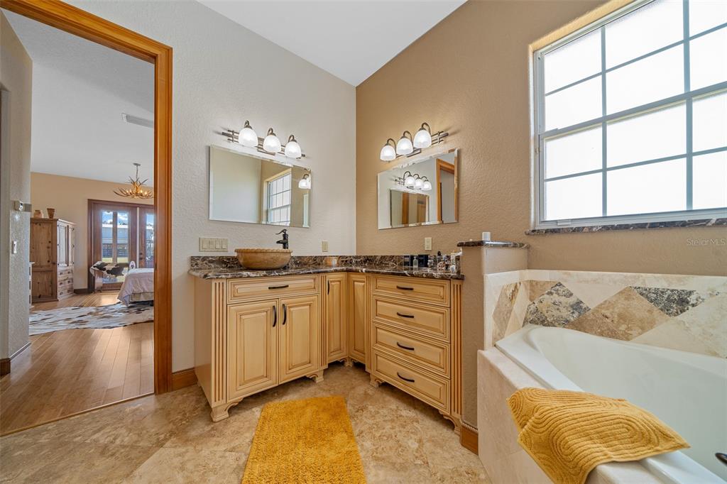 2198 West Highway 329 Citra, FL 32113 - Photo 24 of 57 a spacious bathroom with a granite countertop tub sink and mirror