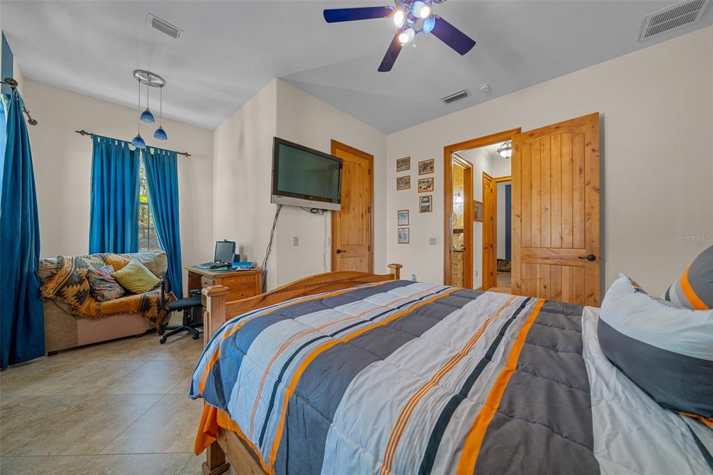 2198 West Highway 329 Citra, FL 32113 - Photo 31 of 57 a bedroom with bed and a chandelier