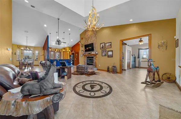 a living room with furniture a chandelier and a fireplace