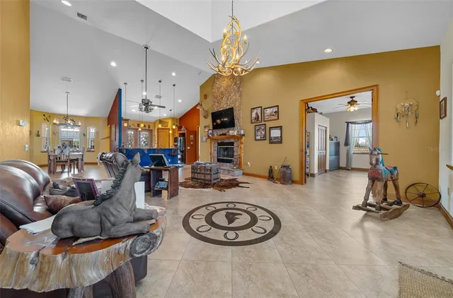 a living room with furniture a chandelier and a fireplace