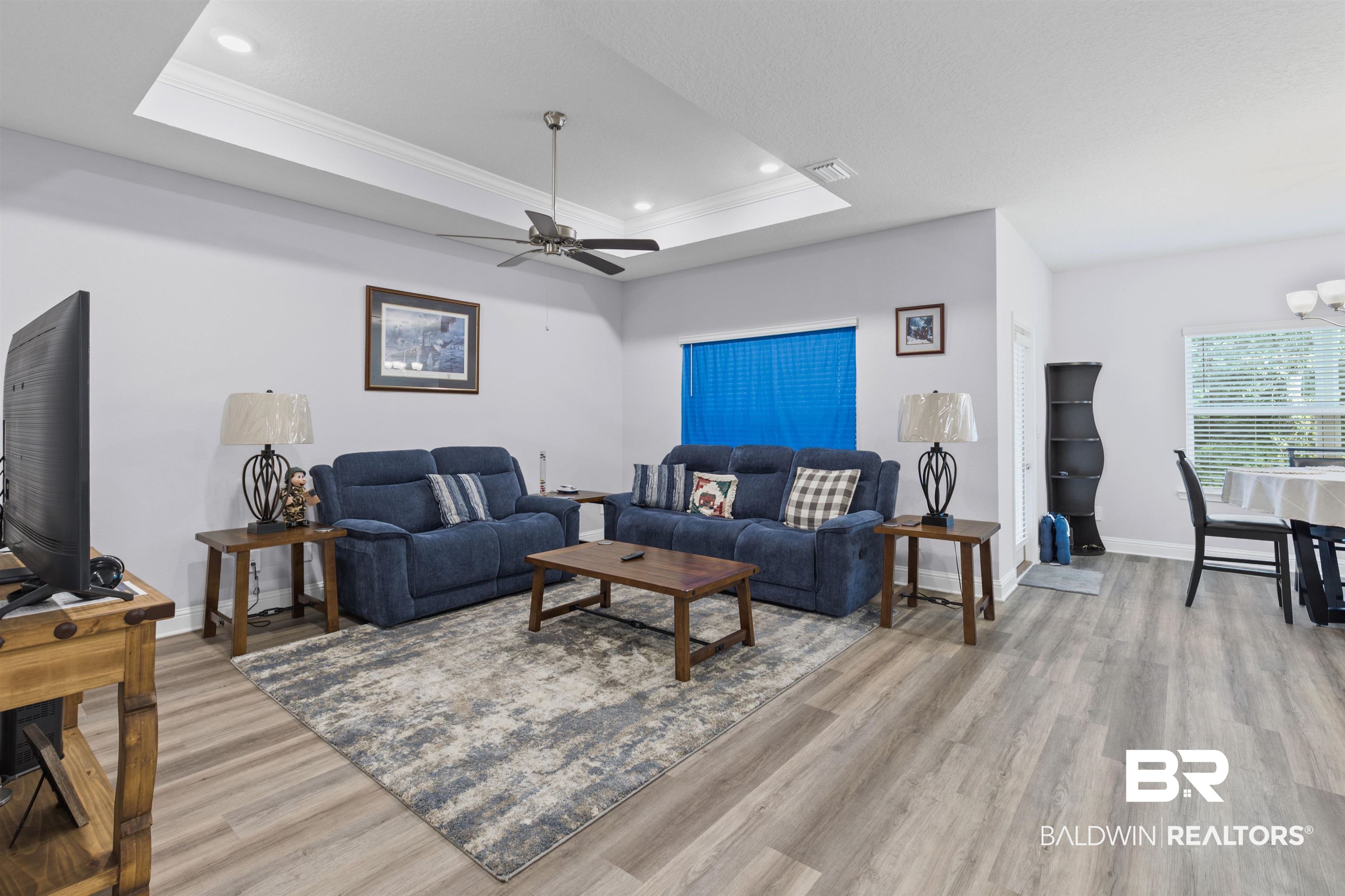 10564 Heirloom Road South Mobile, AL 36608 - Photo 5 of 24 Living room featuring a tray ceiling, crown molding, light wood-style flooring, recessed lighting, and a chandelier