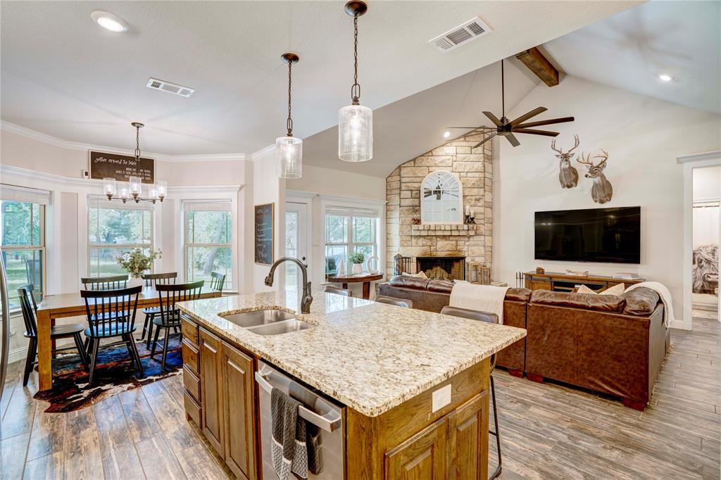 1355 Jay Bird Road Springtown, TX 76082 - Photo 19 of 40 a kitchen with granite countertop a sink appliances and a living room view