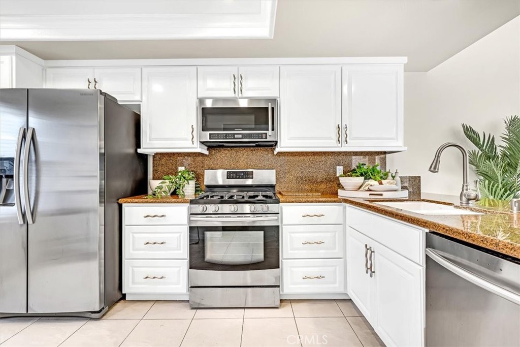 86 Sandpiper, Unit 17 Irvine, CA 92604 - Photo 12 of 56 a kitchen with white cabinets and stainless steel appliances
