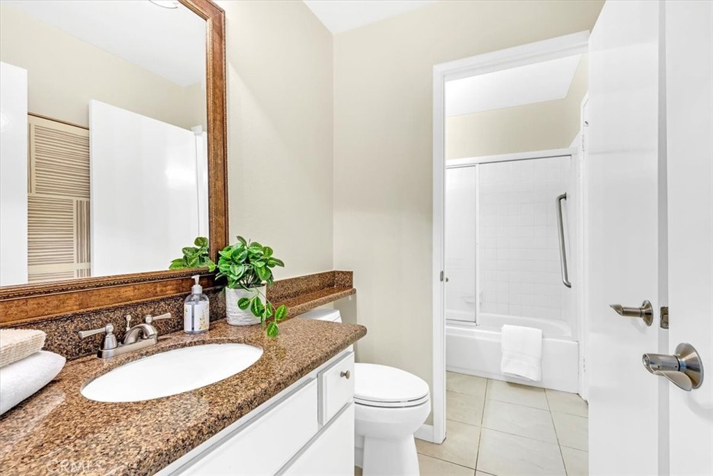 86 Sandpiper, Unit 17 Irvine, CA 92604 - Photo 25 of 56 a bathroom with a granite countertop sink and a mirror with toilet