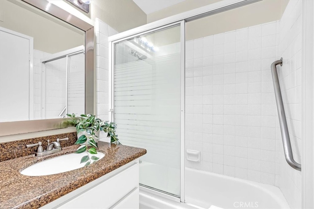 86 Sandpiper, Unit 17 Irvine, CA 92604 - Photo 26 of 56 a bathroom with a granite countertop sink and a mirror a bathtub