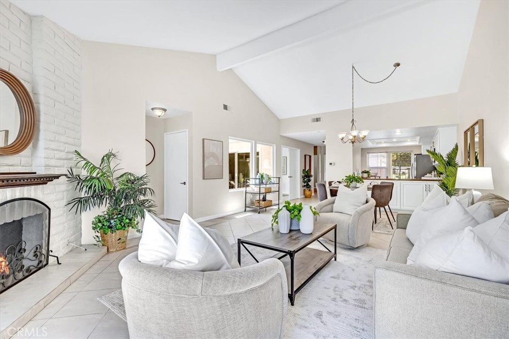 86 Sandpiper, Unit 17 Irvine, CA 92604 - Photo 7 of 56 a living room with furniture a chandelier and a fireplace