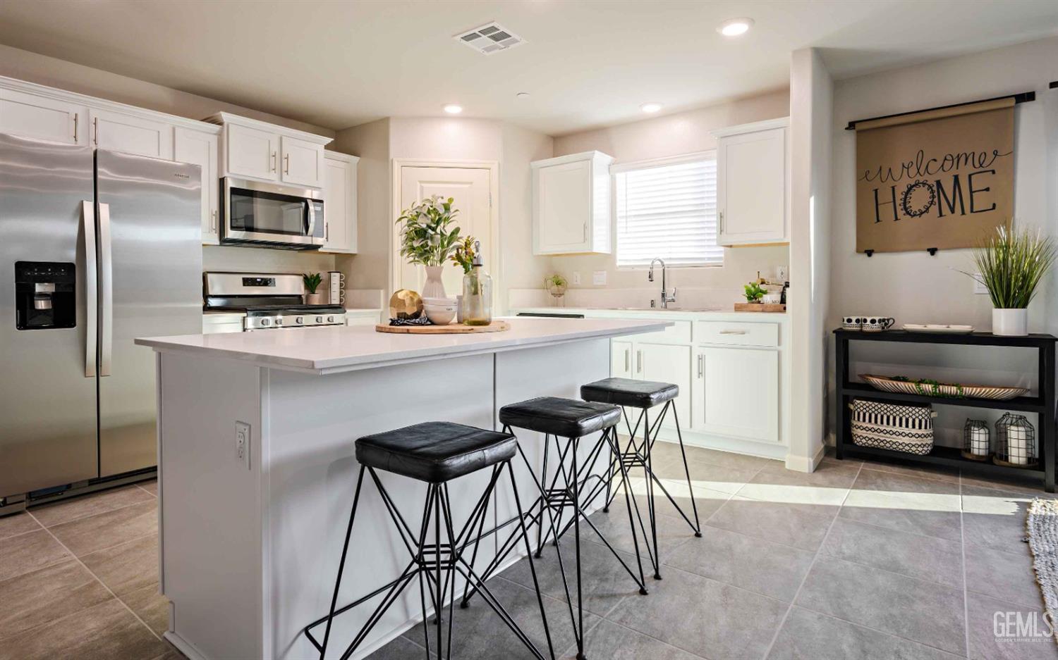 a kitchen with stainless steel appliances granite countertop a table and chairs in it