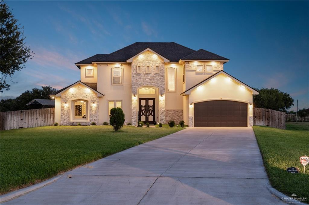 a front view of a house with yard and green space