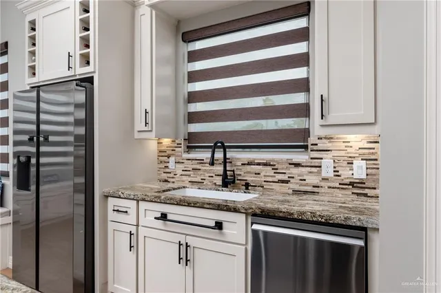 a kitchen with granite countertop cabinets stainless steel appliances and a sink