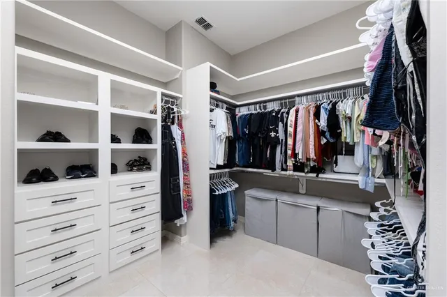 a view of walk in closet with clothes and shoes