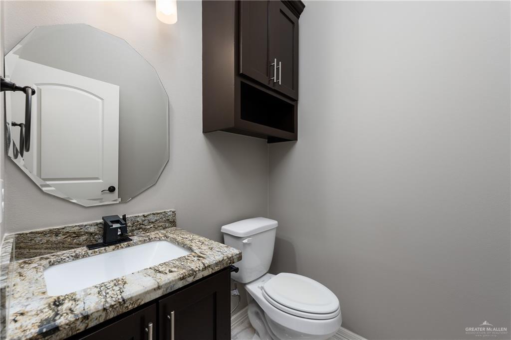 8405 Summer View Court Harlingen, TX 78552 - Photo 22 of 45 a bathroom with a granite countertop toilet sink and mirror