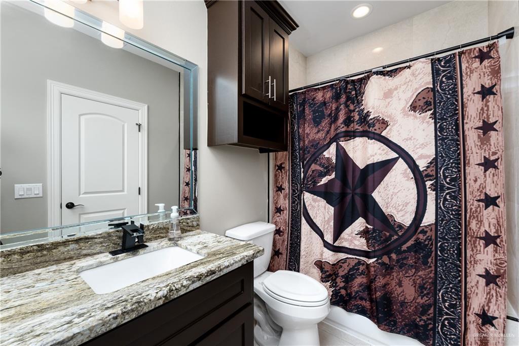 8405 Summer View Court Harlingen, TX 78552 - Photo 31 of 45 a bathroom with a granite countertop toilet sink and mirror