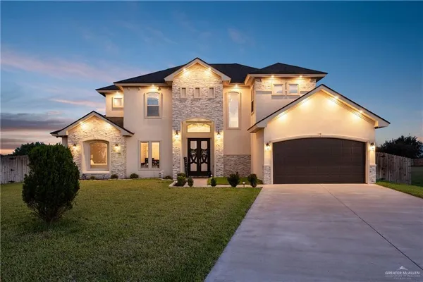 a front view of a house with a garden and yard