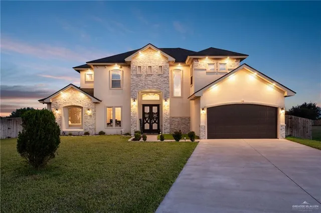 a front view of a house with a garden and yard