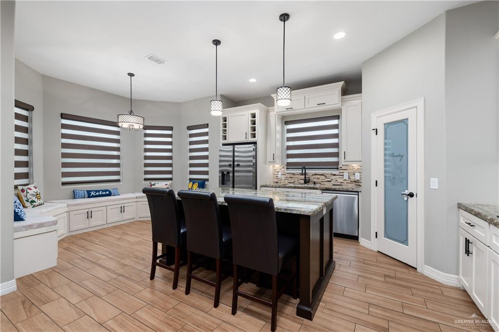 8405 Summer View Court Harlingen, TX 78552 - Photo 9 of 45 a kitchen with stainless steel appliances granite countertop a kitchen island a stove a table and chairs