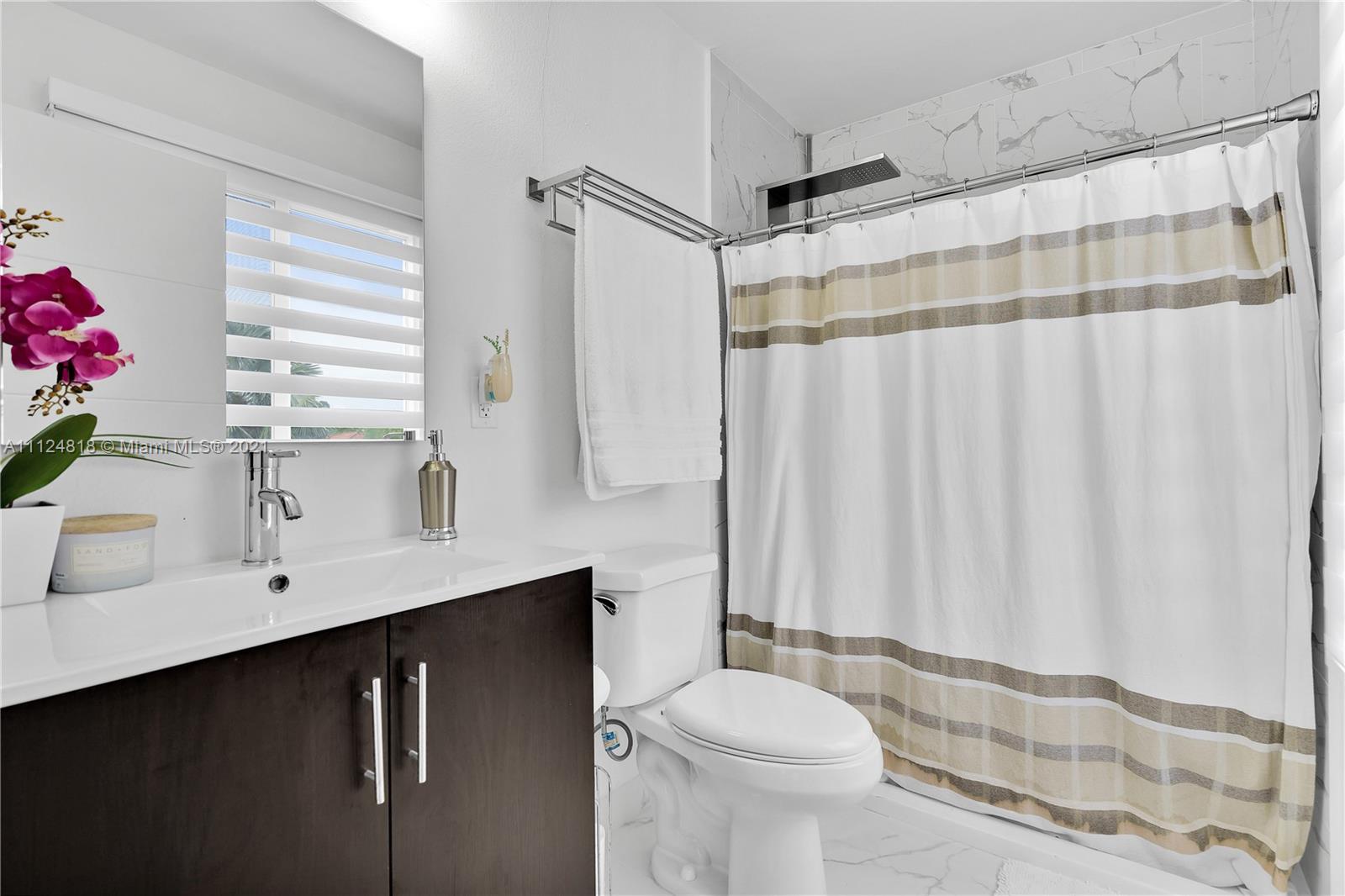 25807 Southwest 139th Court Homestead, FL 33032 - Photo 30 of 32 a bathroom with a sink a toilet and shower curtain
