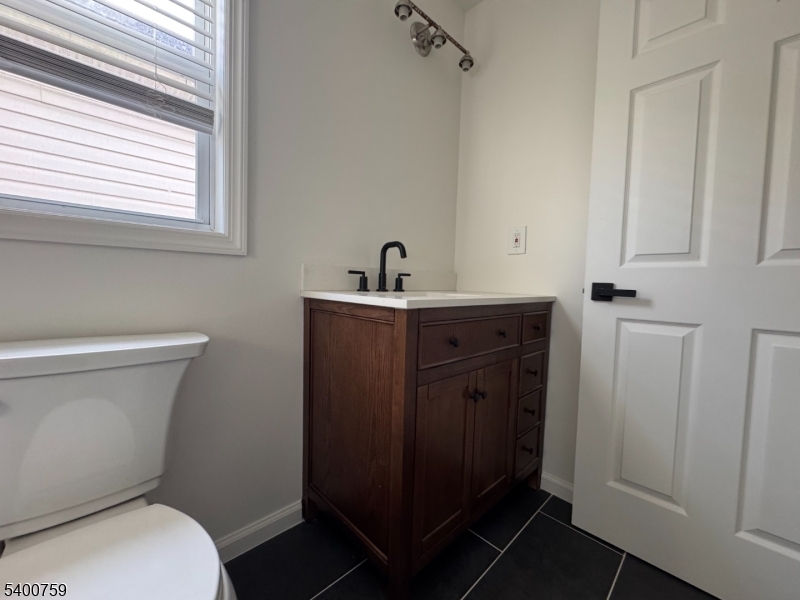 121 12th Avenue Paterson, NJ 07501 - Photo 13 of 14 a bathroom with a toilet a sink a vanity and mirror