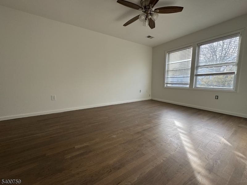 121 12th Avenue Paterson, NJ 07501 - Photo 3 of 14 an empty room with wooden floor and windows